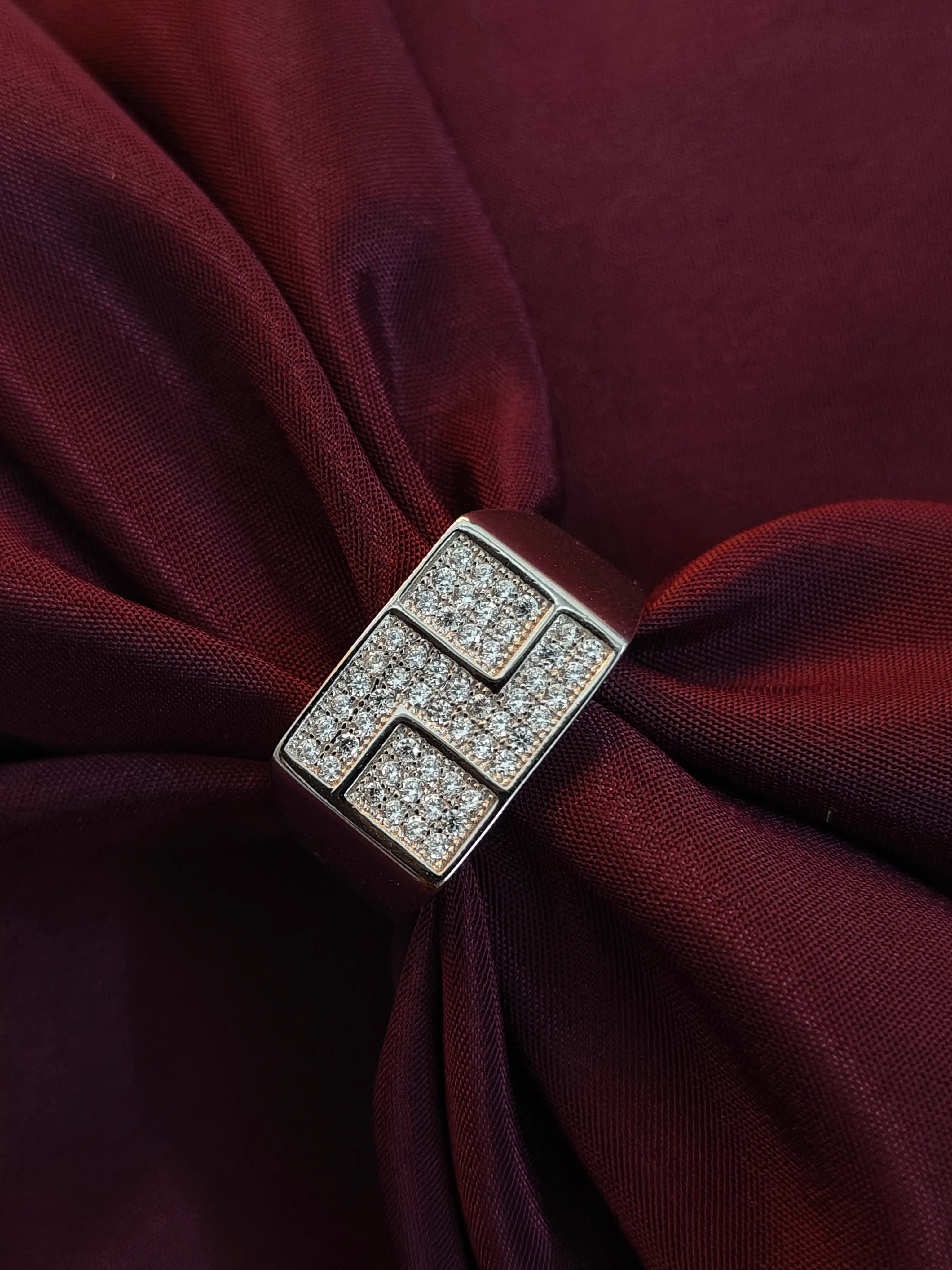 Silver brooch with gemstones on a burgundy fabric background